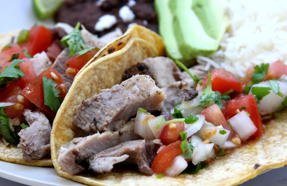 Slow Cooker Carnitas Tacos recipe is garlic studded and seasoned with chipotle, oregano and thyme. Our mouths watered all day while it was cooking.