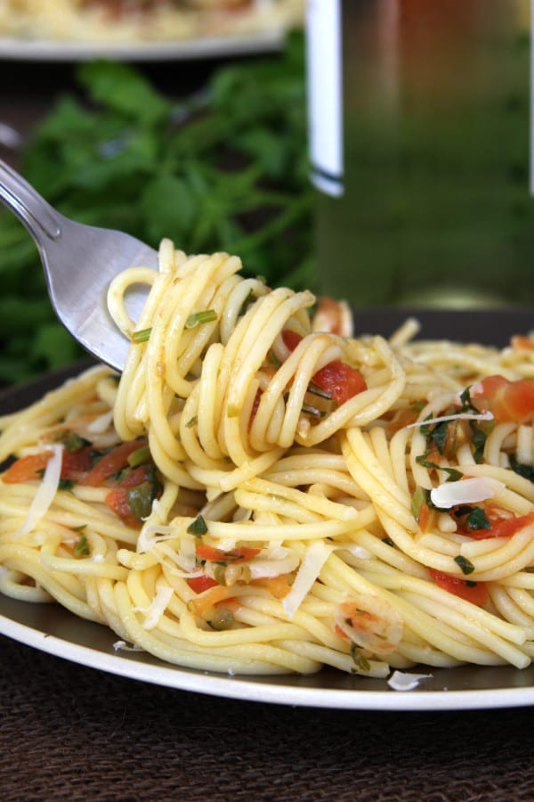 Tomato Caper Pasta is a light & savory dish. Capers, thinly sliced garlic, fresh tomatoes and Italian parsley surround tantalizing al dente pasta. Have this with a glass of chilled white wine and you will feel carried away to a dinner in Italy.