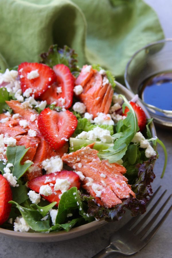 Simple Strawberry Salmon Salad recipe is an easy and healthy meal. Simple olive oil balsamic vinaigrette surrounds juicy strawberries, wild Atlantic salmon and creamy feta. We adore this salad on hot summer nights.