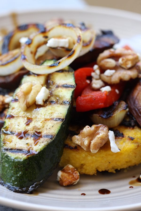 Rustic Italian Grilled Polenta & Vegetables recipe is a healthy & savory dish great for sharing. Polenta has flavors of rosemary and parmesan and is surrounded by grilled veggies and a balsamic reduction. Portable, tasty and vegetarian.
