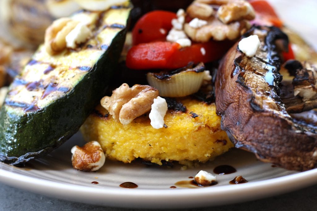 Rustic Italian Grilled Polenta & Vegetables recipe is a healthy & savory dish great for sharing. Polenta has flavors of rosemary and parmesan and is surrounded by grilled veggies and a balsamic reduction. Portable, tasty and vegetarian.