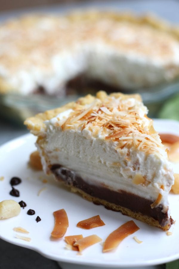 A cherished Hawaiian dessert,Haupia Pie with Macadamia Crust is as exciting to eat as attending your first luau. This gorgeous pie has a flaky and nutty crust, rich coconut chocolate layer, coconut cream layer all topped with fluffy whipped cream. You will be in heaven from the first bite.