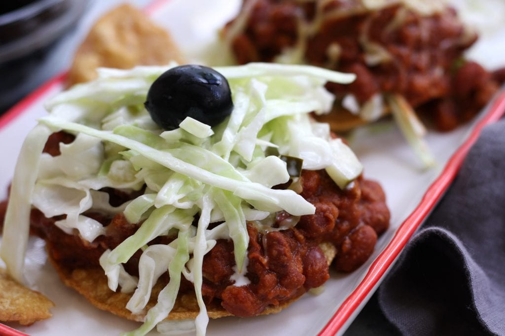 Tortilla and Beans is a family recipe dating back over 70 years. A crispy corn tortilla is topped with a hearty chili, simple coleslaw and black olives. Delicious, satisfying and budget friendly, this is a meal my husband can't get enough of.