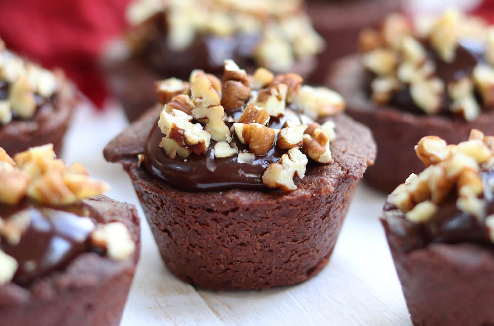Cinnamon Kissed Cocoa Cup Cookies are absolute fudgy goodness. A chocolate sugar cookie holds creamy cinnamon chocolate ganache and is topped with chopped pecans.