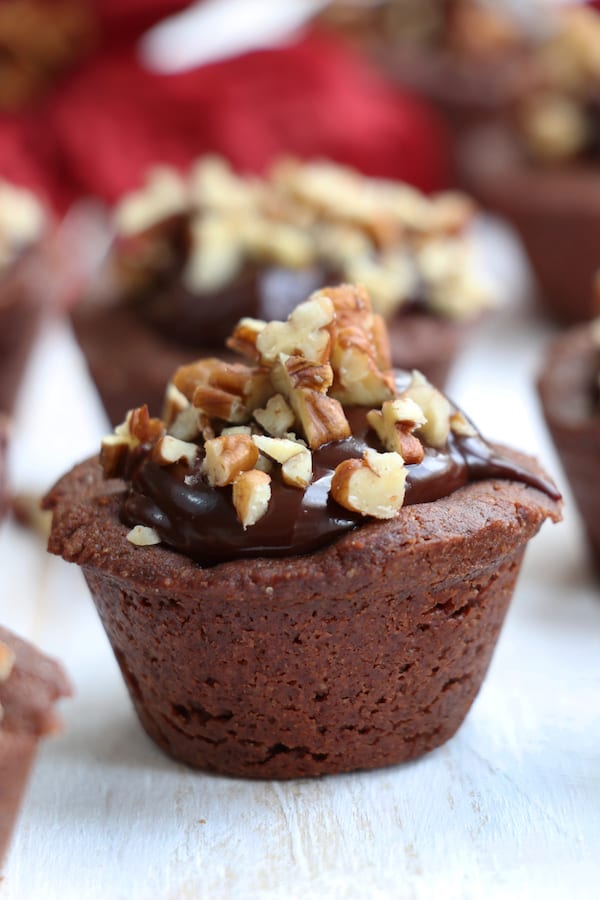 Cinnamon Kissed Cocoa Cup Cookies are absolute fudgy goodness. A chocolate sugar cookie holds creamy cinnamon chocolate ganache and is topped with chopped pecans.