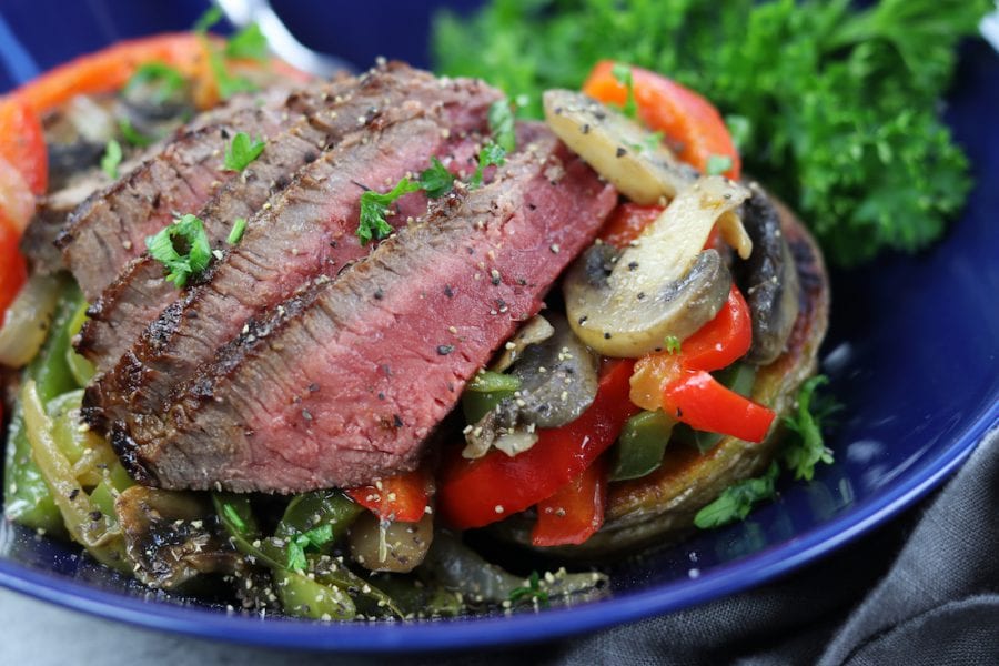 Veggie Cheesesteak Potatoes recipe has tender steak, red wine sautéed veggies, creamy homemade cheese sauce over a crispy potato.