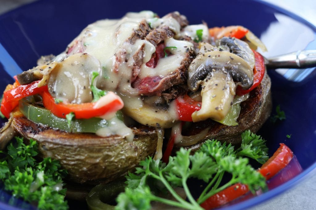 Veggie Cheesesteak Potatoes recipe has tender steak, red wine sautéed veggies, creamy homemade cheese sauce over a crispy potato.