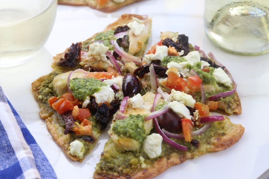 Easy and delicious, Chicken Pesto Naan Pizza comes together in minutes with kalamata olives, goat cheese and sun-dried tomatoes. Perfect for busy weeknights without composing flavor.