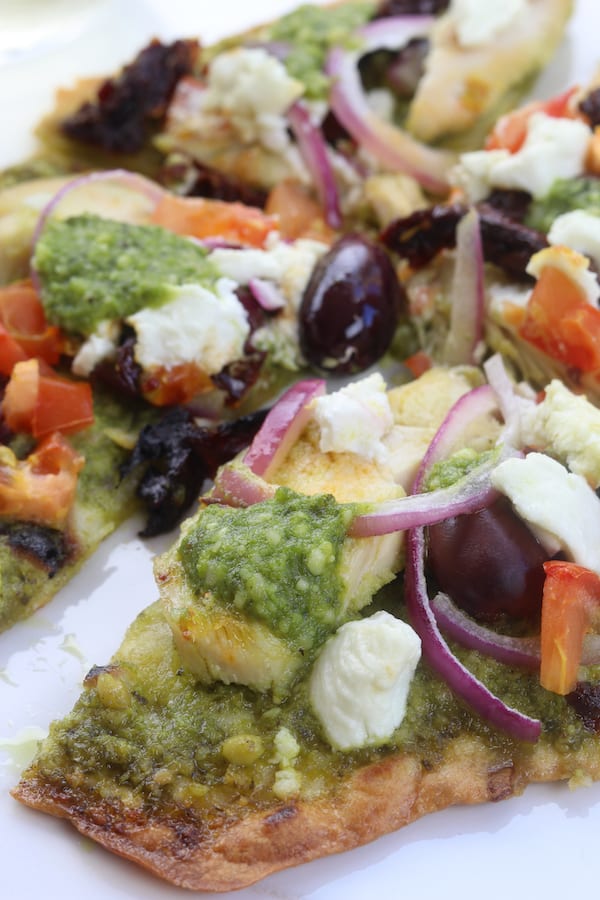 Easy and delicious, Chicken Pesto Naan Pizza comes together in minutes with kalamata olives, goat cheese and red onions. Perfect for busy weeknights without composing flavor.