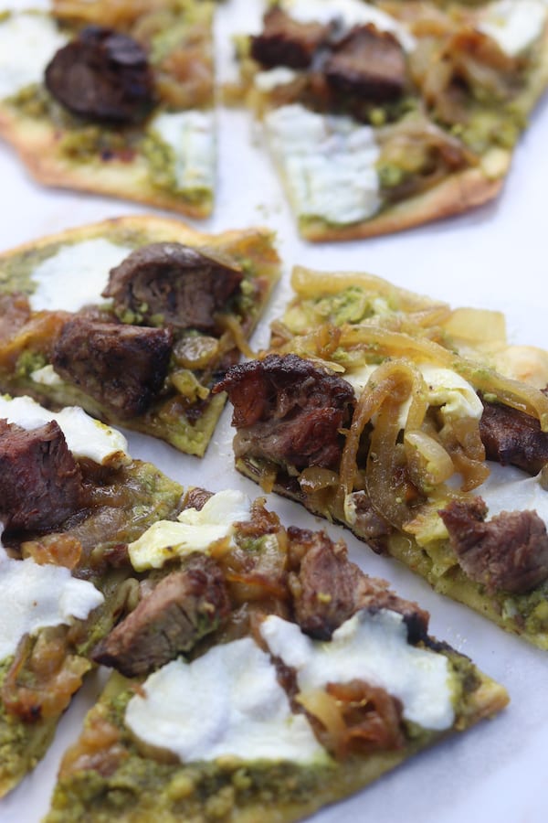 Caramelized Onion Steak Naan Pesto Pizza has the perfect marriage of sweet buttery caramelized onions, herby pesto and satisfying steak. Ingredients can be made ahead of time for a delicious dinner that comes together in a little over 10 minutes.