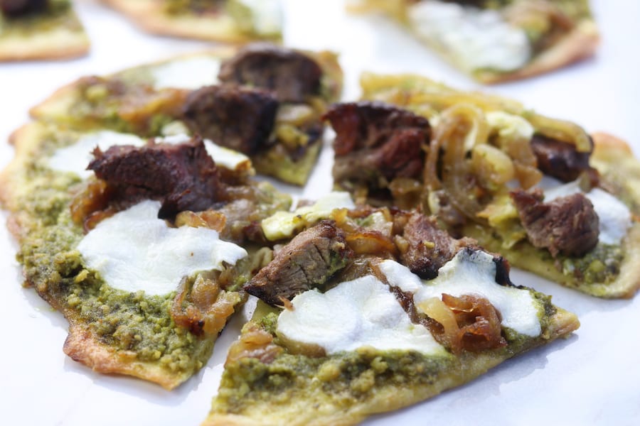Caramelized Onion Steak Naan Pesto Pizza has the perfect marriage of sweet buttery caramelized onions, herby pesto and satisfying steak. Ingredients can be made ahead of time for a delicious dinner that comes together in a little over 10 minutes. 