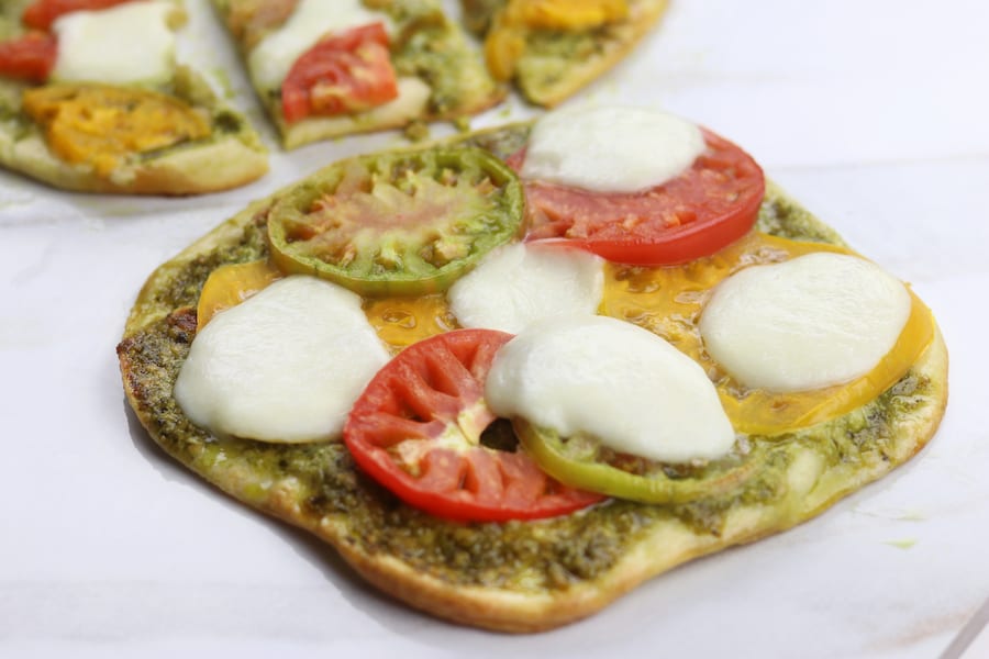 Light and summery, Heirloom Tomato Pesto Naan Pizza is a quick and easy recipe perfect for curing the take out cravings.