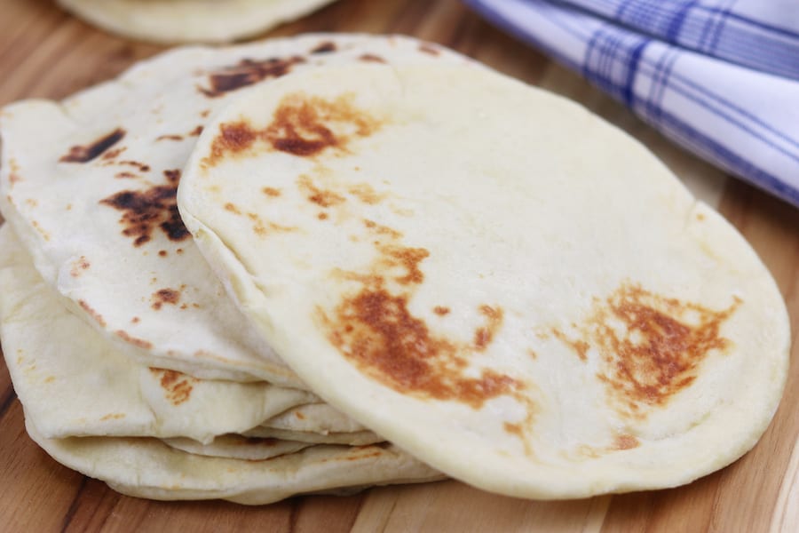 Learn the basics of making Homemade Naan, an easy & fluffy skillet bread that goes perfectly with Indian dishes or can be used to make pizza. 