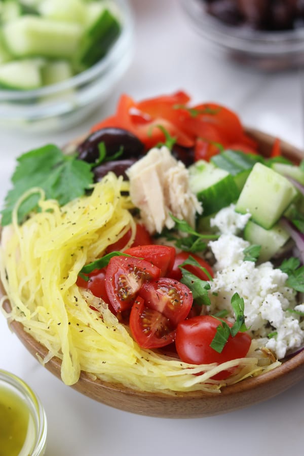 Spaghetti Squash Greek Bowls are an easy low fat and low-carb meal perfect for summer. Mix and match your favorite Greek toppings and drizzle on the popular dressing. You will love these!