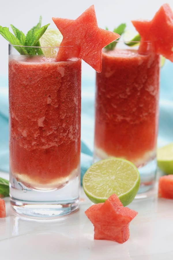 Frozen Watermelon Mojitos is the drink of summer! An adult-beverage speckled with mint, a hint of lime, watermelon simple syrup and incredibly refreshing icy watermelon. It is dangerously delicious!