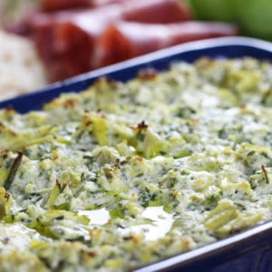 Close up of Baked Lemon Artichoke Dip with a drizzle of olive oil.