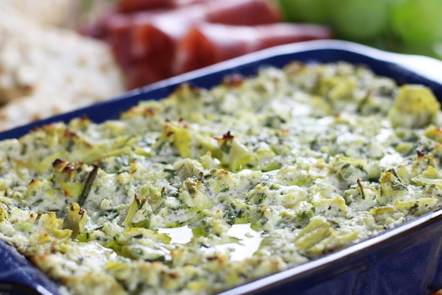 Close up of Baked Lemon Artichoke Dip with a drizzle of olive oil.