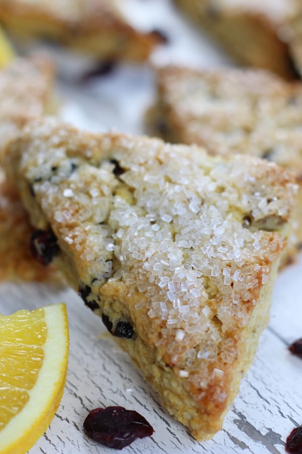 Cranberry Orange Scones displayed with orange slice and dried cranberries.
