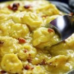 Spoon dipping into a bowl of Creamy Butternut Tortellini Soup.