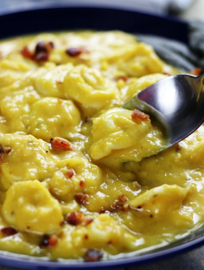 Spoon dipping into a bowl of Creamy Butternut Tortellini Soup.