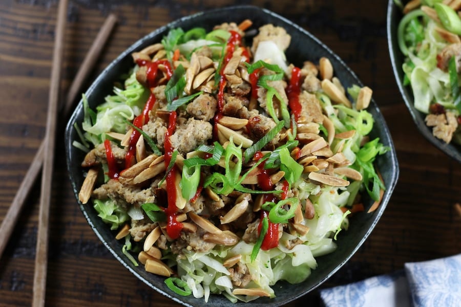 Low Carb Egg Roll In a Bowl garnished with green onions and sitting on a table.