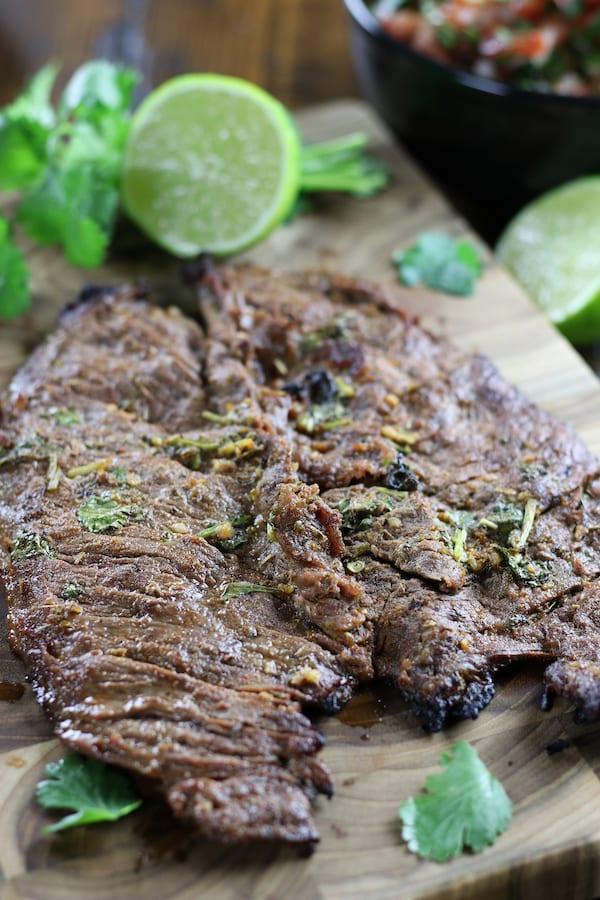 Flap steak on a cutting board marinaded and grilled in Carne Asada Marinade Recipe.