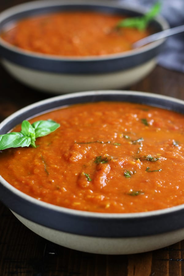 Two servings of Easy Tomato Basil Soup with fresh basil.