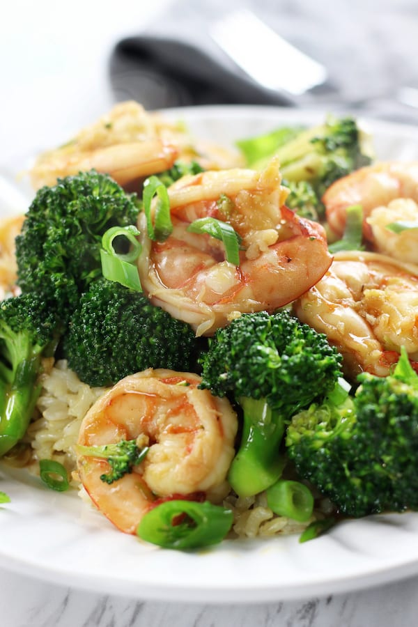 A plate of Garlic Shrimp Stir Fry on a bed of rice.