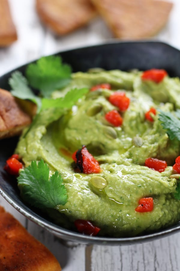 Smooth Avocado Hummus with roasted red bell peppers and cilantro.