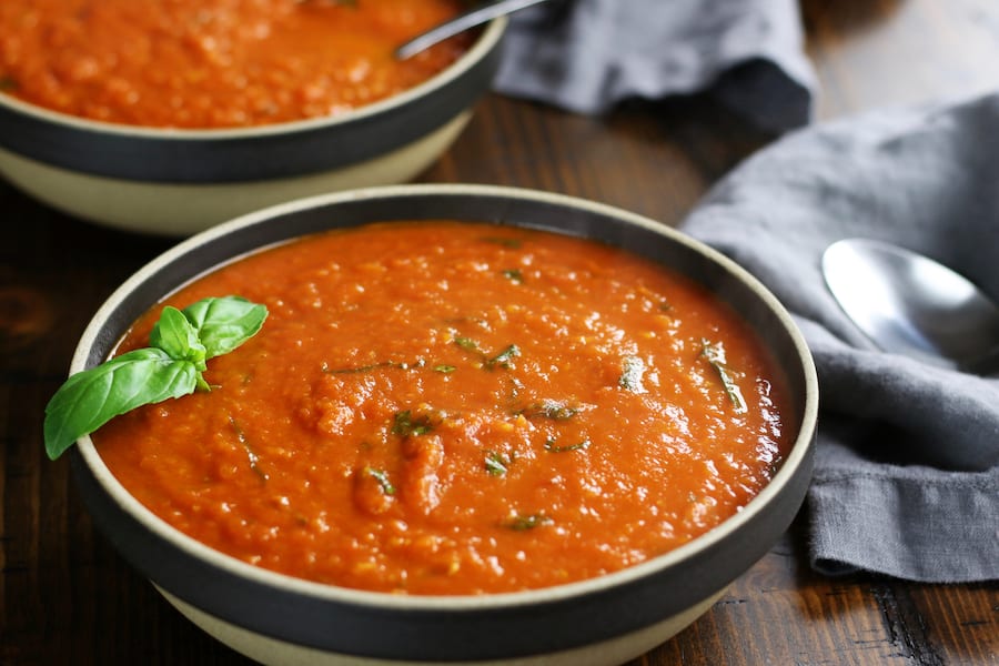 Bowls of Tomato Basil Parmesan Soup sitting on a table.