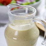 Bottle of Lemon Tahini Salad Dressing sitting on a table.