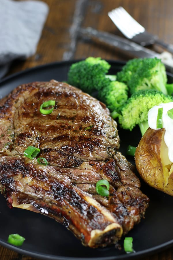 Cooked steak on a plate after being marinated in Rib Eye Steak Marinade.