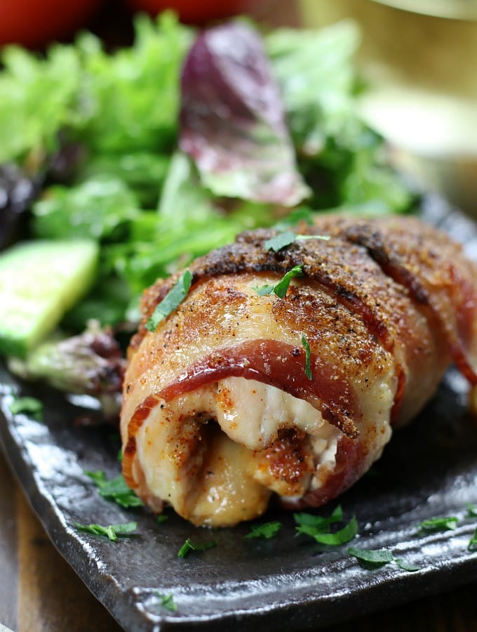 Bacon Wrapped Chicken on a plate with salad.