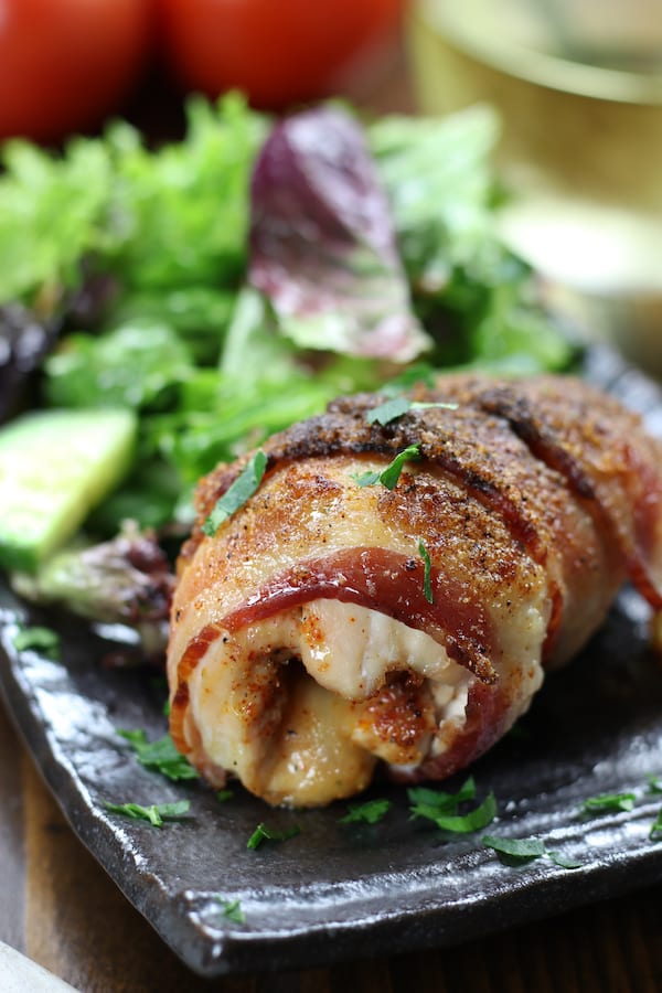 Cheese Stuffed Chicken Breast that is bacon wrapped on a gray plate.