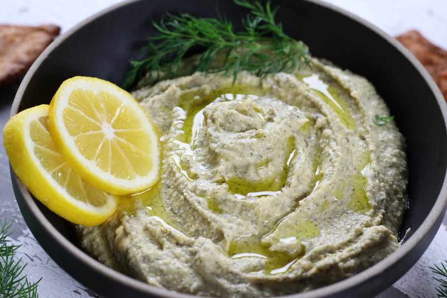 A bowl of Garbanzo Bean Hummus with lemon and fresh dill.