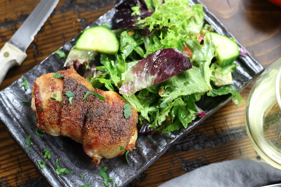 Stuffed Chicken Breast Recipe on a dinner plate with salad.