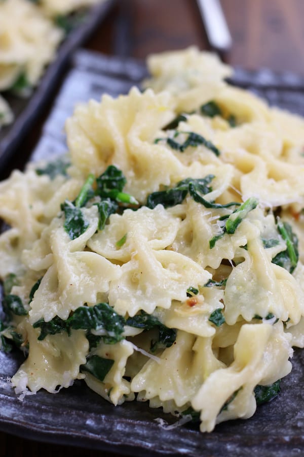 Easy Bow Tie Pasta with Spinach on a plate with melted parmesan.