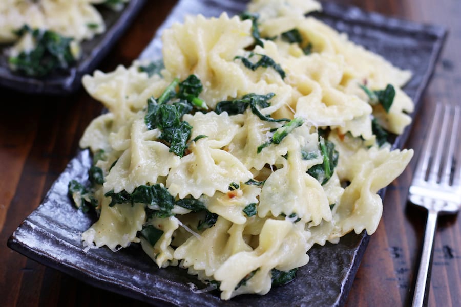 Overhead photo of Simple Creamy Pasta with spinach on a grey wavy plate.