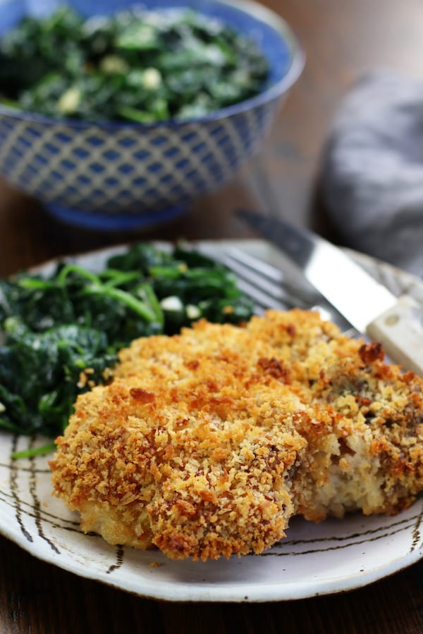 A single serving of Breaded Baked Pork Chops and sautéed spinach.