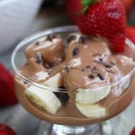 A clear glass dessert cup filled with cut fruit and Chocolate Yogurt Fruit Dip.