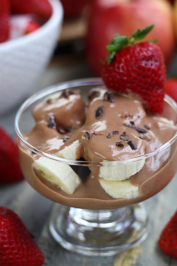 A clear glass dessert cup filled with cut fruit and Chocolate Yogurt Fruit Dip.