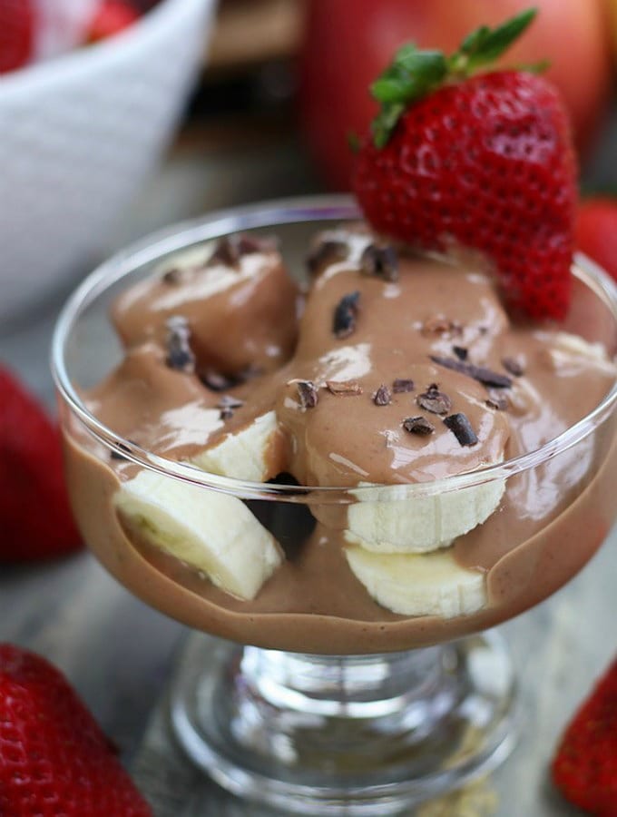 Chocolate Yogurt Fruit Dip Parfait with cut banana and cacao nibs.