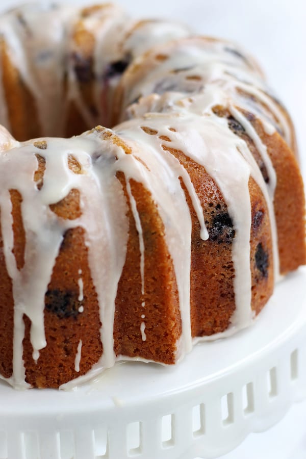 Lemon Blueberry Cake in a bundt shape on a cake stand.