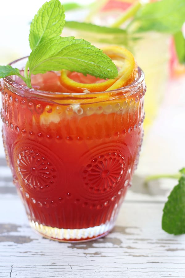 A frosty glass of Passionfruit Mocktail on a white board.