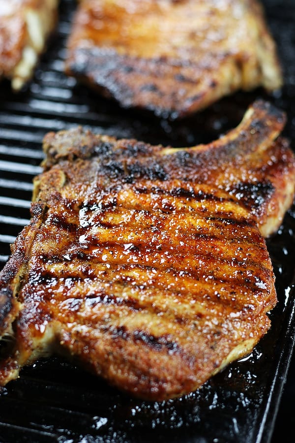 Pork Chops In Oven cooking on a cast iron griddle.