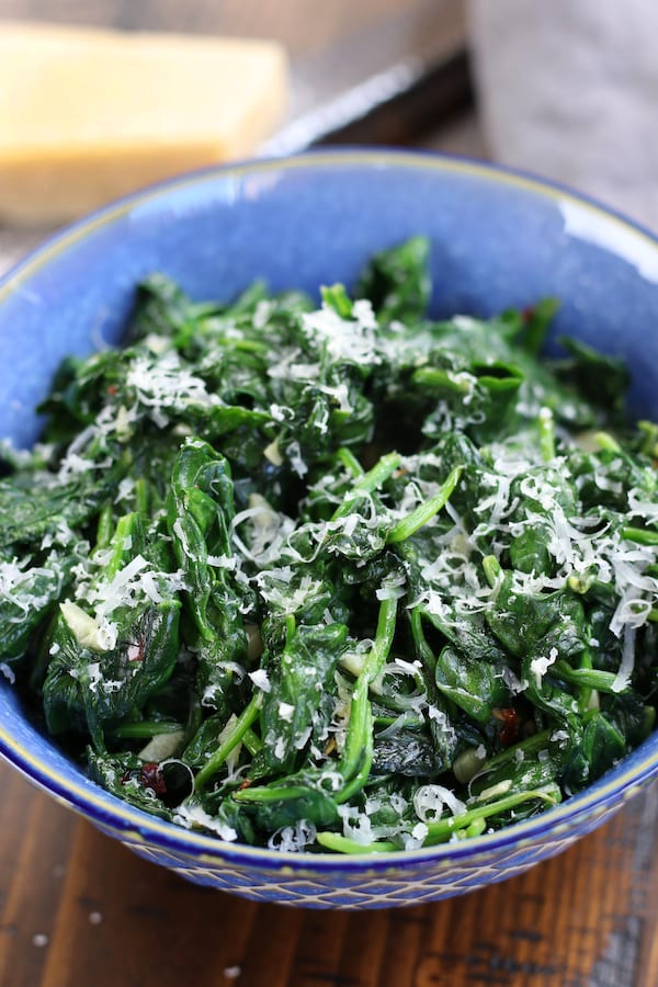 Sautéed Spinach in a blue bowl with parmesan.