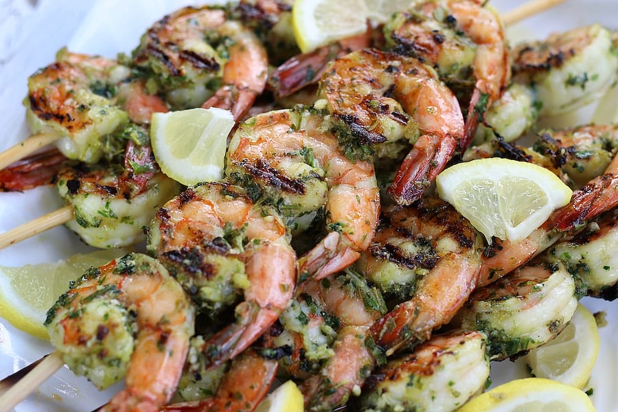 Several Grilled Shrimp Kabobs on a white platter.