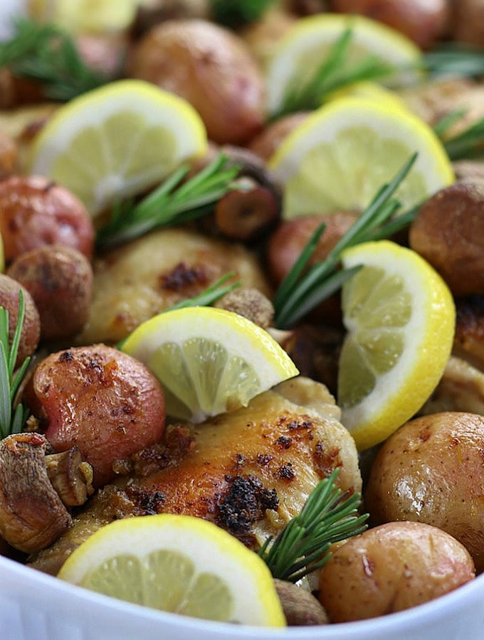 Lemon Rosemary Chicken and Potato Bake with fresh lemon slices and rosemary sprigs.