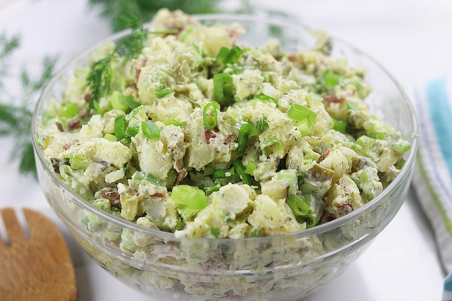 Red Potato Salad Recipe sitting on a white table.