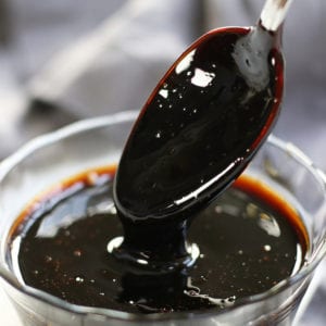 The start of Balsamic Reduction being drizzled from a spoon.